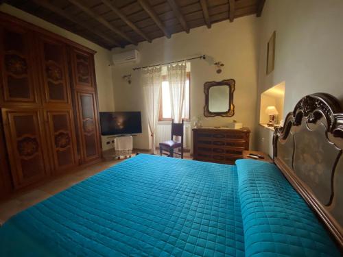 维泰博Antico Casale Edifizio的一间卧室配有蓝色的床和电视