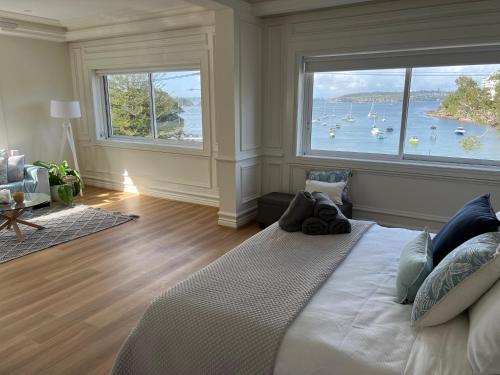 悉尼Tusan Villa Little Manly的一间卧室设有大窗户,水中设有船只
