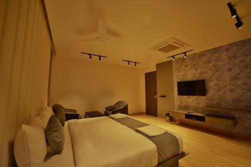 迈索尔The Mysore Grand的酒店客房,配有床和电视