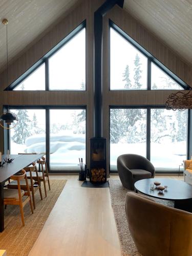 洛夫斯达伦Nybyggd 8-bäddars skidstuga i Lofsdalen的客厅设有大窗户和桌椅