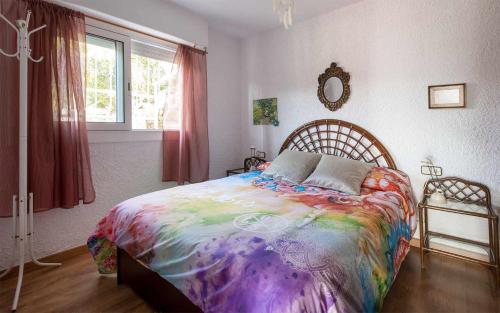 滨海托萨Xalupa Salions Vistas的一间卧室配有一张大床和色彩缤纷的毯子
