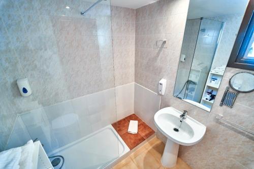 卡拉恩·布拉內斯Apartamentos Blue Beach Menorca的一间带水槽、浴缸和淋浴的浴室
