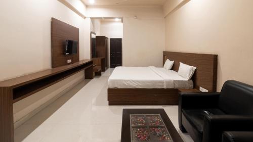 加雅Namastay Welcome Home -Gaya的一间卧室配有一张床、一张沙发和一台电视