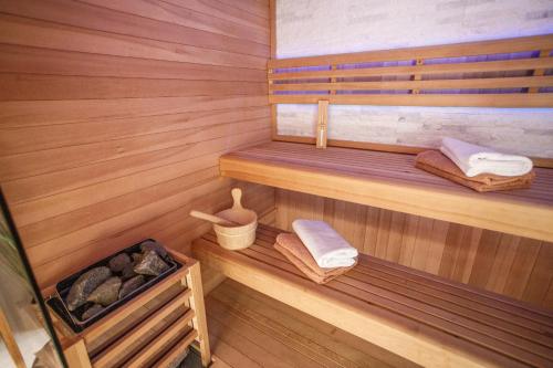 米欧纳Nono Jure , private pool & sauna的一间设有木墙、木地板和毛巾的桑拿浴室