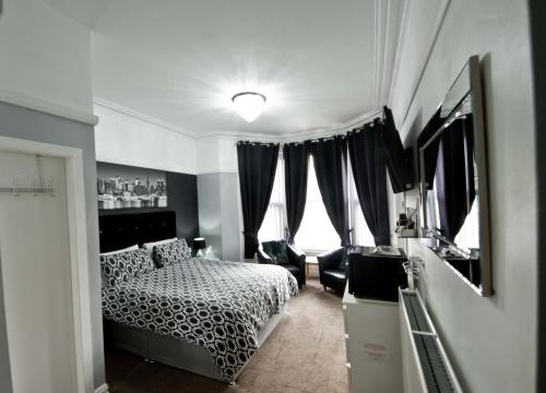 布莱克浦Rossall House , For Families & Couples的一间卧室设有一张床和一个大窗户