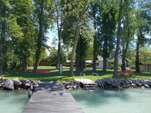 福纽德Fonyód Camping & Apartman的一条木桥,在河上,有两把椅子