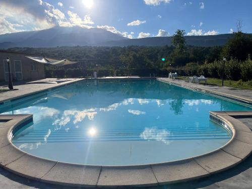 PuntalazzoIdda ,ospitalità Siciliana .的一个大型蓝色游泳池,后面是群山