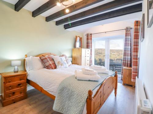 兰戈伦Alwyn Cottage的一间卧室设有一张大床和一个窗户。