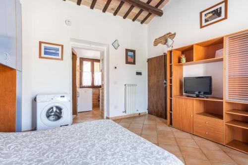 基亚拉瓦莱Monolocale la casa dei sogni的一间卧室配有一张床、一台电视和一台洗衣机