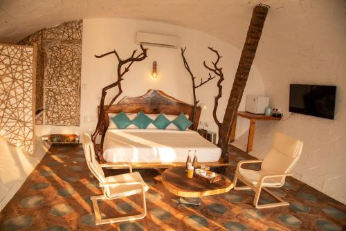 Cabo de RamaObrigado by Craftels的一间卧室配有一张床、两把椅子和一张桌子