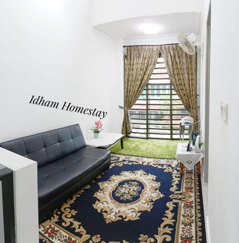 怡保Idham Homestay的客厅配有黑色沙发和地毯。