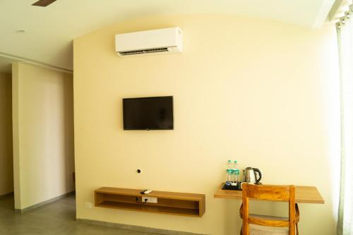 GolāghātChang's Garden & Resort的一间设有桌子的房间和墙上的电视