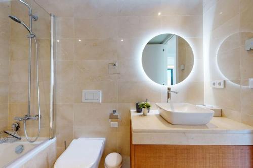 卡拉德米哈斯Luxury Townhouse in La Cala De Mijas的浴室配有盥洗盆、镜子和浴缸