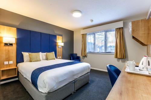 斯丹斯达蒙费雪特伦敦斯坦斯特德机场戴斯酒店的酒店客房设有一张大床和一张桌子。