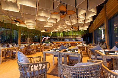 金边SUN & MOON, Riverside Hotel的一间带桌椅的餐厅和一间酒吧