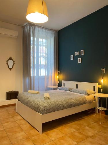 那不勒斯B&B La Terrazza Napoli的一间卧室设有一张床和蓝色的墙壁