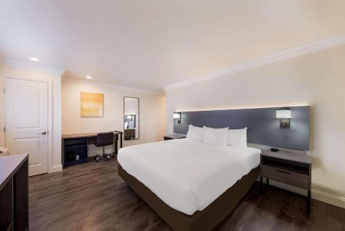 吉尔罗伊Comfort Inn Gilroy的酒店客房设有一张大床和一张书桌。