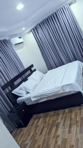 贝宁城Naboya House Serviced Apartment的卧室内的一张带天蓬的床