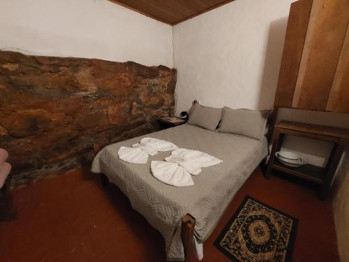巴埃彭迪Pouso do Tropeiro - Cavalgadas Roseta的一间卧室配有带毛巾的床