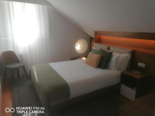 里斯本Timeless - Energy - Belém的一间卧室设有一张床、一个窗口和一把椅子
