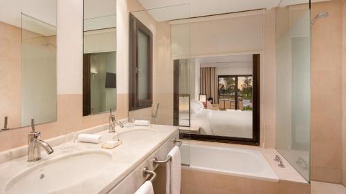 弗安特阿拉莫Ona Hacienda del Álamo Golf Resort的浴室设有2个水槽、浴缸和镜子