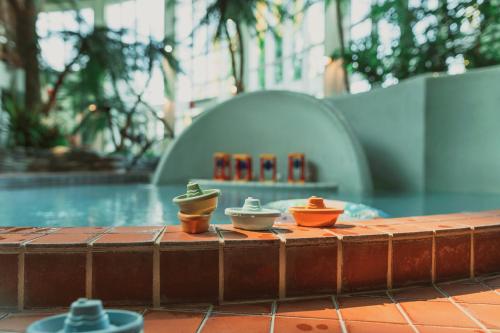 沃卡蒂卡提库塔假日俱乐部酒店的三个杯子坐在泳池旁的桌子上