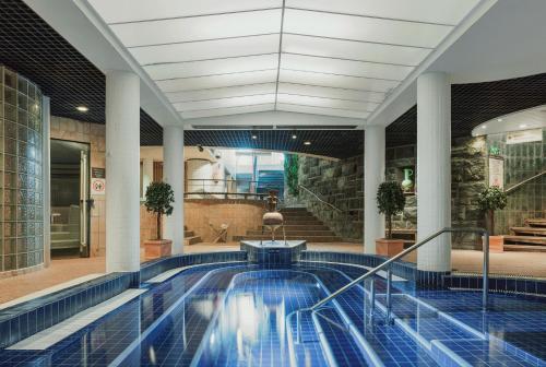 沃卡蒂卡提库塔假日俱乐部酒店的游泳池,位于带大堂的建筑内