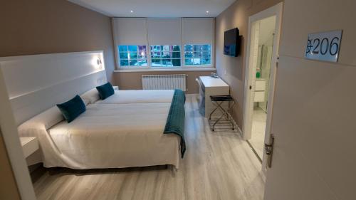 索托德尔瓦尔科Hotel El Parador的一间卧室配有一张床、一张书桌和一个窗户。