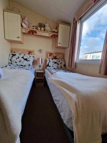 赛伦塞斯特Caravan in the Cotswolds的小型客房 - 带2张床和窗户