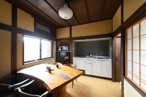金泽UFU Kanazawa的厨房以及带木桌的用餐室。