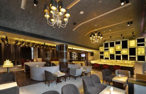 新德里Udman Hotel Chhattarpur的一间带桌椅和吊灯的餐厅