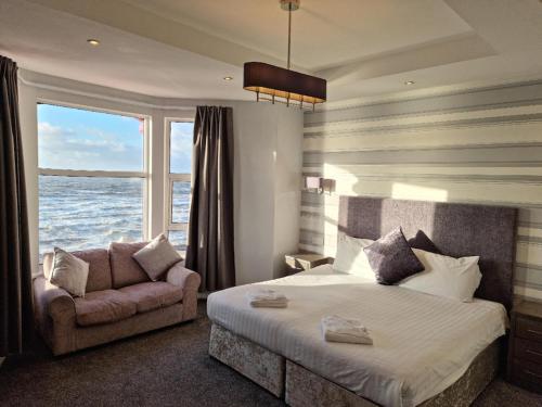 布莱克浦蒂凡尼酒店的一间卧室配有一张床、一张沙发和一个窗口