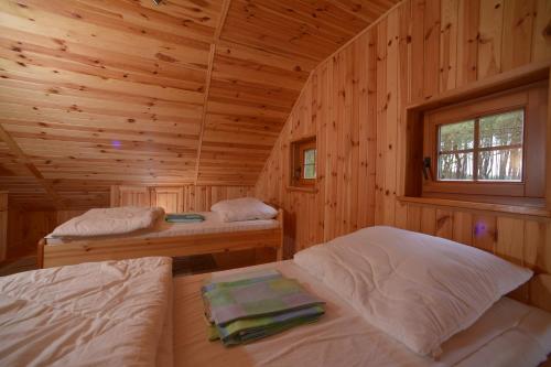 德兹维济诺Domki przy plaży - Pod Wydmami的小木屋内一间卧室,配有两张床