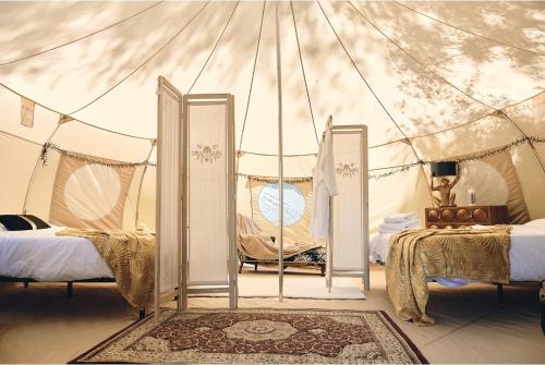 Margouët-MeymèsCamping d'artagnan的一间帐篷内带两张床的卧室