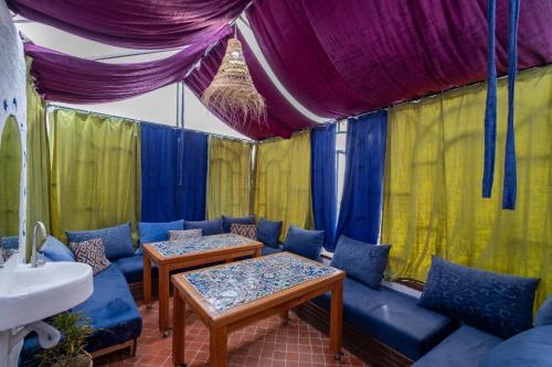 舍夫沙万Riad Mosaic的帐篷内配有沙发和桌子的房间