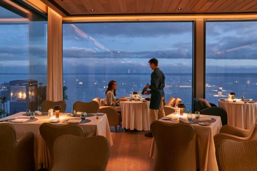 丰沙尔Les Suites at The Cliff Bay - PortoBay的男人和女人站在带桌子的餐厅里
