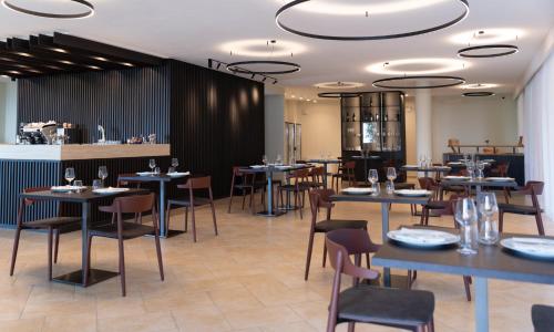 圣焦万尼亚皮罗特努塔特里博斯克酒店的一间带桌椅的餐厅和一间酒吧