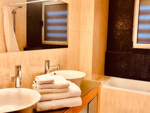 布拉加Bracara luxury guesthouse的浴室配有盥洗盆、镜子和毛巾