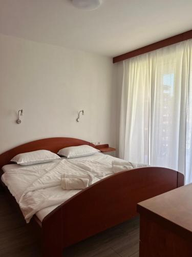 摩拉瓦托普利采Apartment Aurora的一间卧室配有一张带白色床单的床和一扇窗户。
