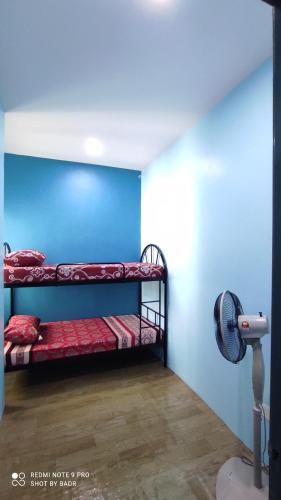 加央Ain's Homestay的客房设有两张双层床和风扇。