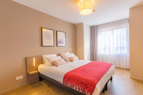 斯特拉斯堡Appart'City Confort Strasbourg Centre的一间卧室配有一张带红色毯子的大床