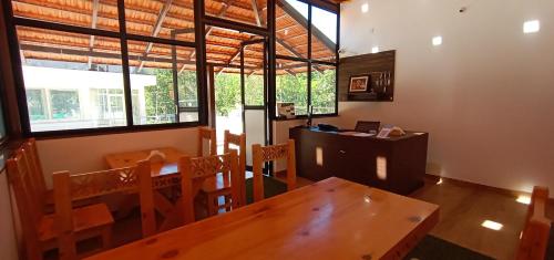 阿提贡迪Kurinji Inn的一间带桌椅和窗户的用餐室