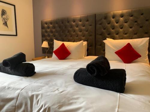 柯克沃尔Kingston House的卧室配有白色的床和红色和黑色枕头