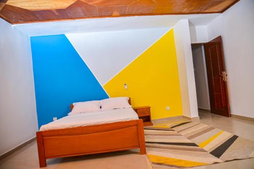 雅温得Appartement meublé 2 chambres avec salle de bain - 1 salon - 1e cuisine - La Concorde - Quartier Nkomkana的一间卧室设有一张床和色彩缤纷的墙壁