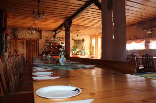 SzteklinAgroturystyka Kociewiak的一间长长的用餐室,配有一张带盘子的长桌