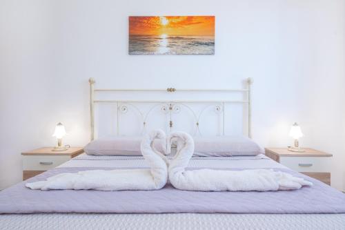 托雷瓦多Villetta Maredorat Vista Mare by HDSalento的两只天鹅用毛巾制成,坐在床上