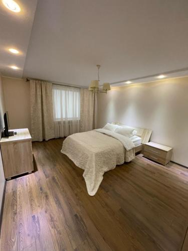 陶拉格Dviejų kambarių butas的一间卧室设有一张大床,铺有木地板