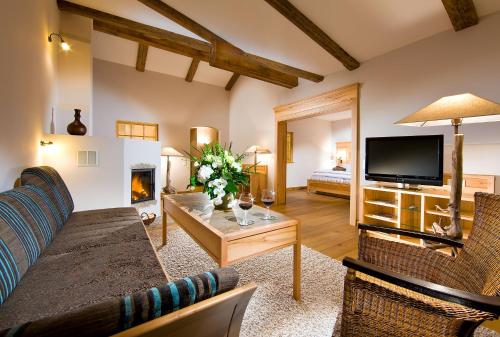 拉姆绍雷勒格博格贝斯特韦斯特优质酒店的带沙发、电视和壁炉的客厅