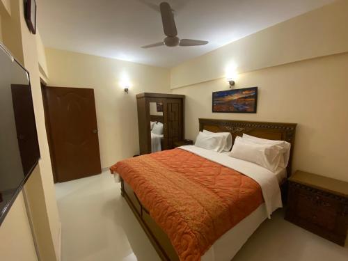 卡拉奇3 Bed Apartment的一间卧室配有一张床和吊扇