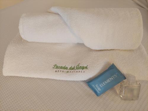 帕丘卡德索托Posada del Ángel的毛巾和两条毛巾旁的一瓶肥皂